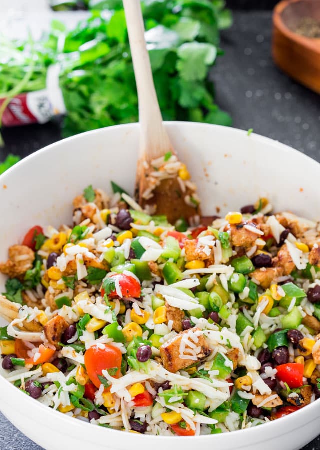 Mexican Chicken and Rice Salad in a big white bowl with a spoon in it