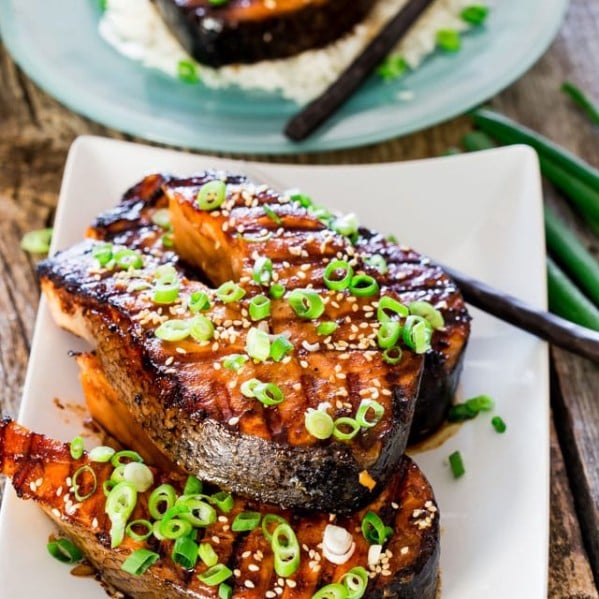 two maple soy grilled salmon steaks stacked on a plate