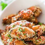 a bowl full of crispy baked parmesan chicken wings