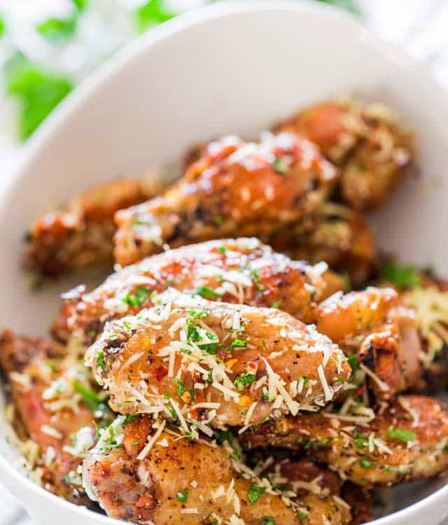 a bowl full of crispy baked parmesan chicken wings