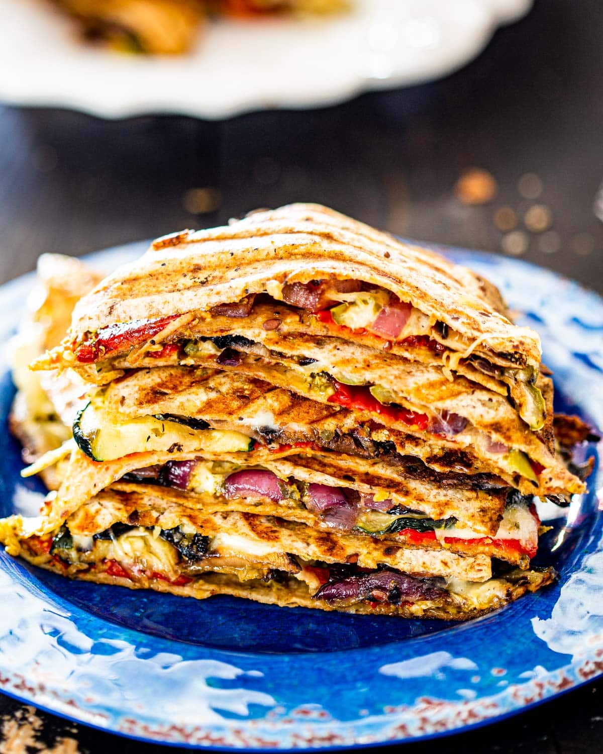 a stack of grilled vegetable quesadillas on a blue plate