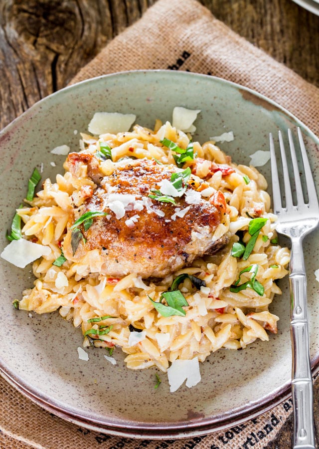a serving of chicken and orzo in a green plate