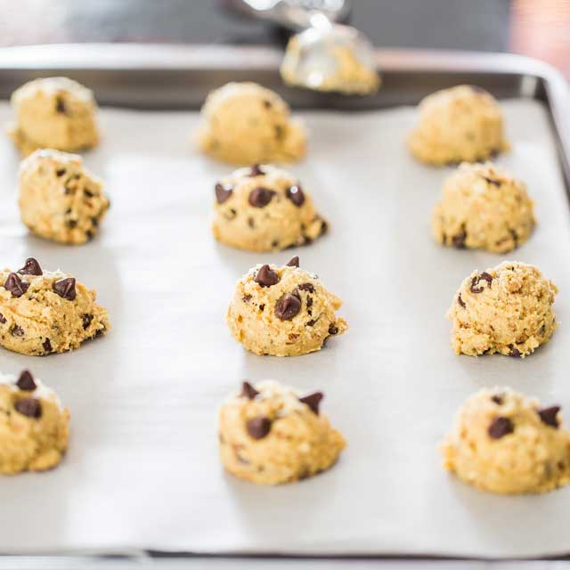 Hazelnut Toffee Chocolate Chip Cookie dough scooped up into balls on a baking sheet ready for the oven