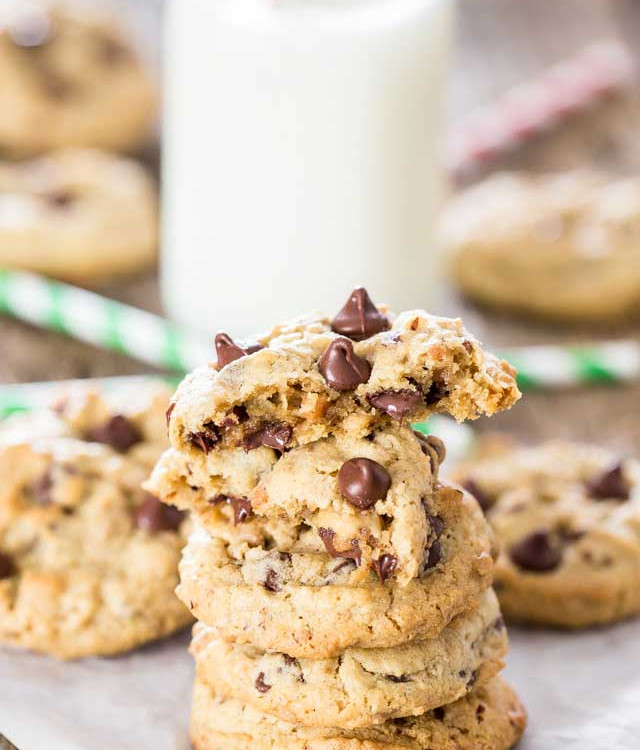 a stack of hazelnut toffee chocolate chip cookies with the top one split in half