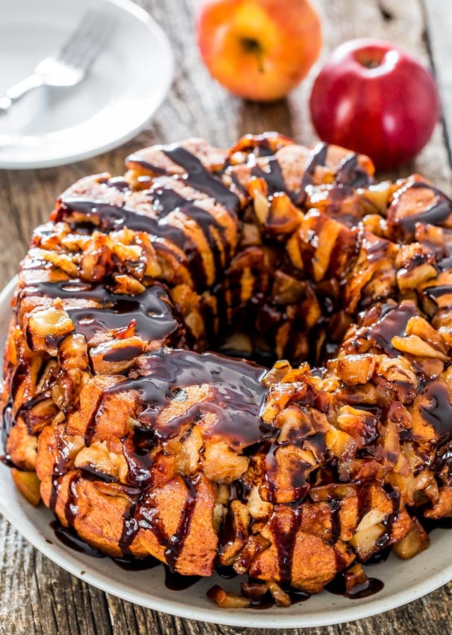 apple pie monkey bread on a plate drizzled with chocolate sauce