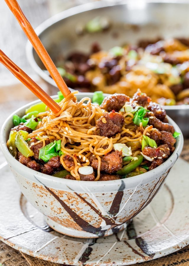 chopsticks stuck in a bowl full of mongolian beef ramen noodles