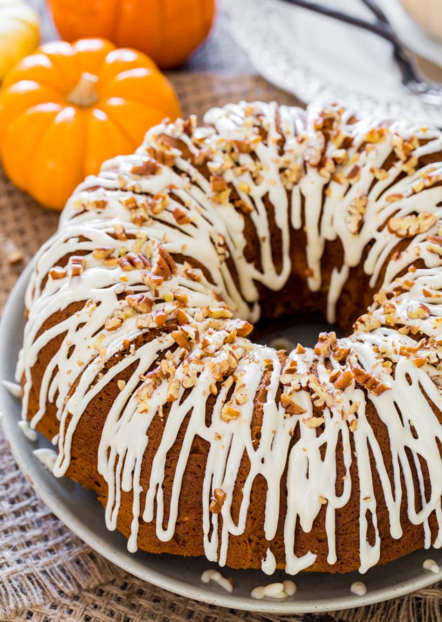 Pumpkin Bundt Cake with Cream Cheese Filling on a platter topped with pecans