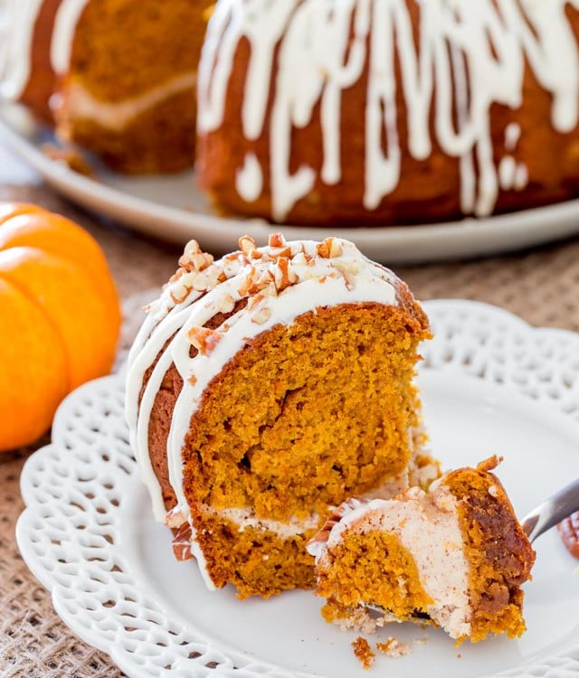a fork taking a bite of pumpkin bundt cake with cream cheese filling
