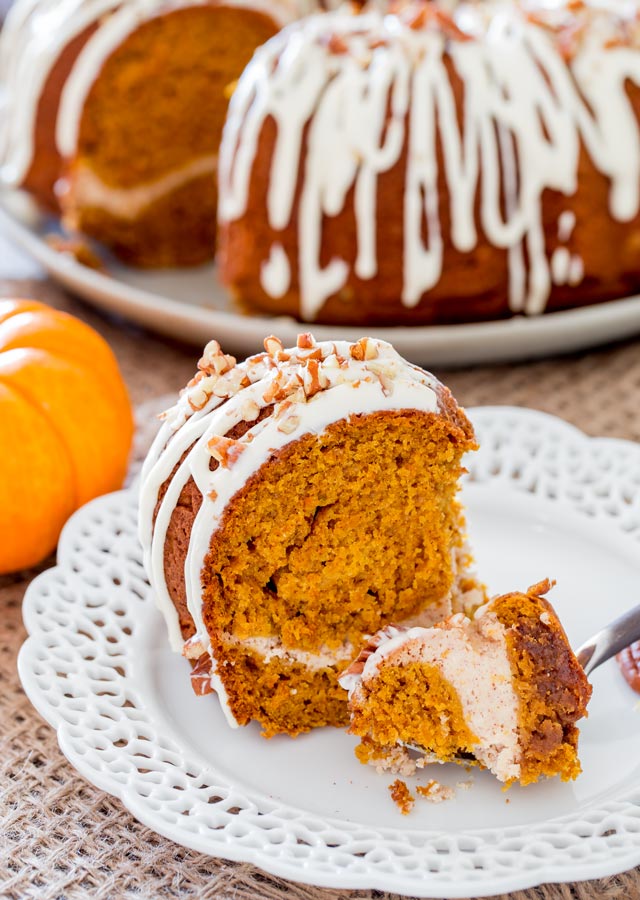 a slice of pumpkin bundt cake filled with cream cheese and glazed with cream cheese icing