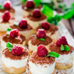 mini tiramisu cheesecakes topped with raspberries on a plate