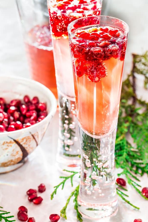 sparkling pomegranate elderflower cocktails with pomegranate floating in it