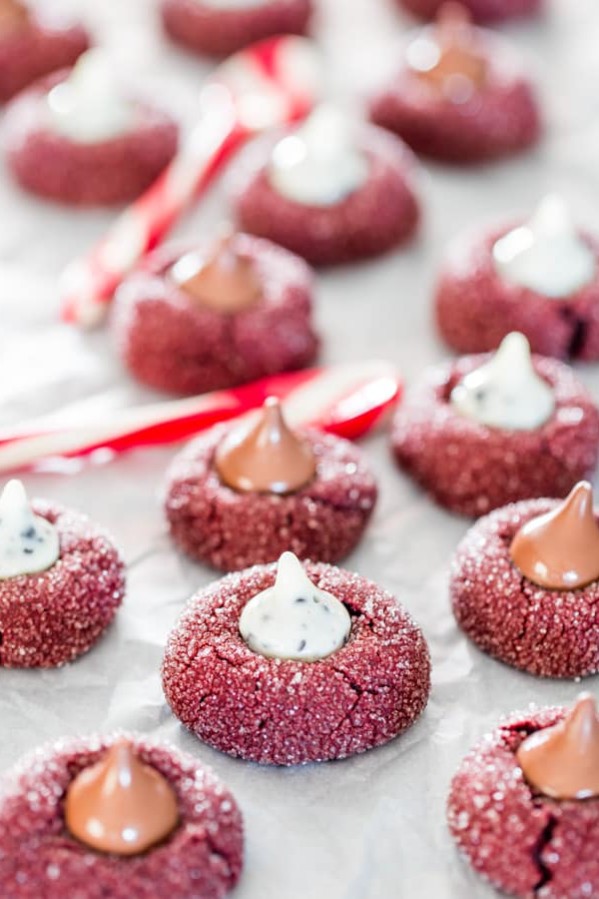 red velvet kiss cookies spread out on parchment paper