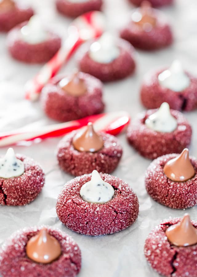 red velvet kiss cookies spread out on parchment paper