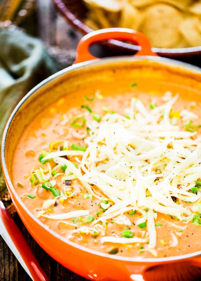 Cheesy Chicken Enchilada Soup topped with cheese in a Dutch Oven