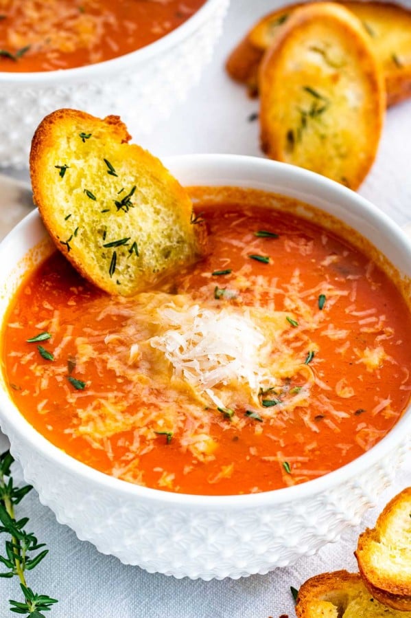 roasted tomato soup in a white bowl with toasted bread.