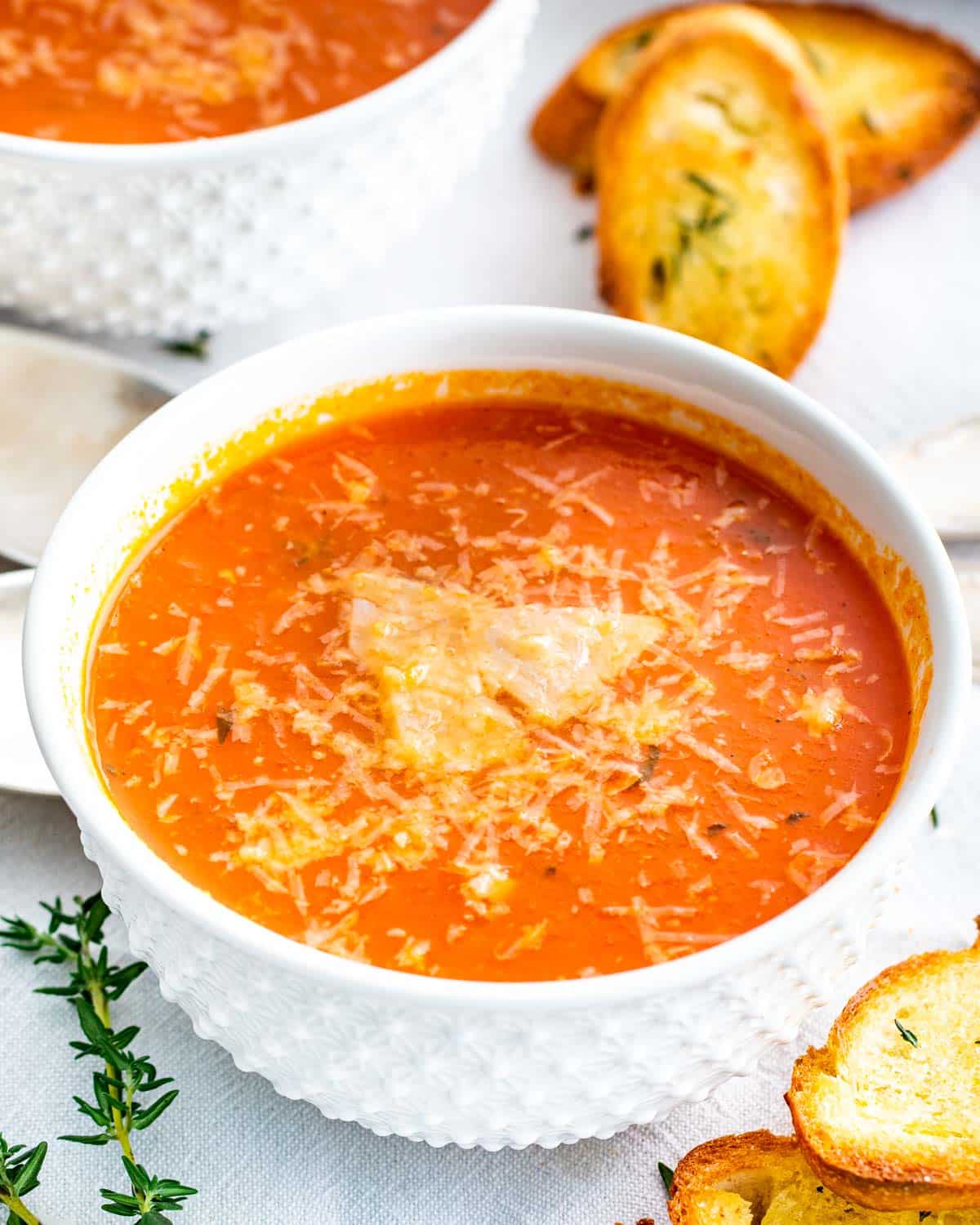 roasted tomato soup in a white bowl with toasted bread.