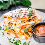 a stack of pizzadillas on a plate with a side of marinara