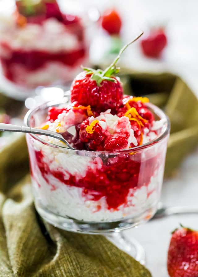 Coconut Rice Pudding topped with berries with a spoon