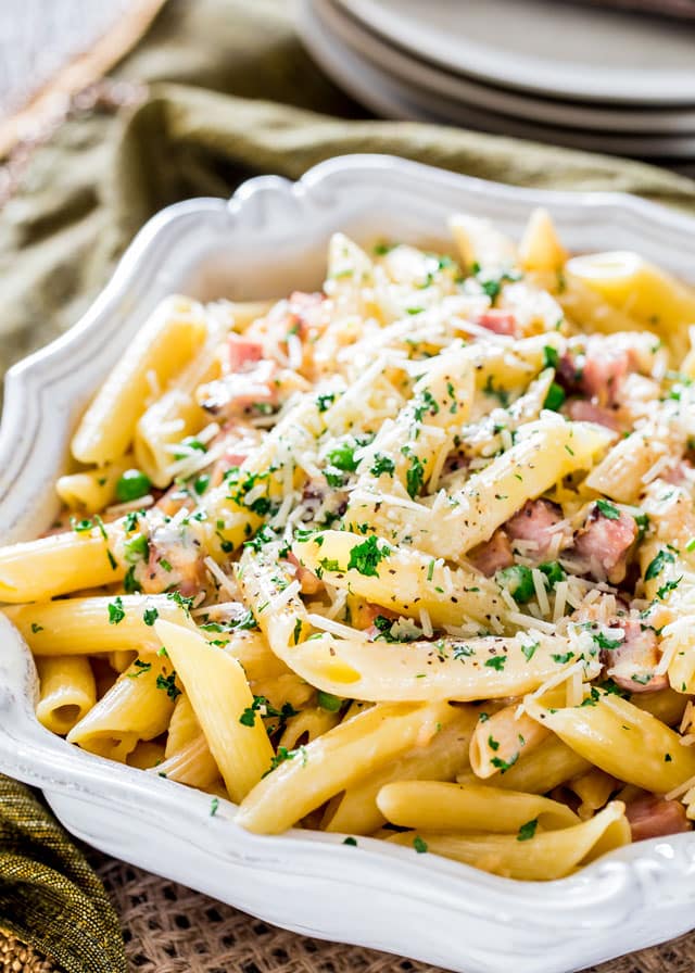 a serving bowl of Ham and Cheese Penne topped with parsley