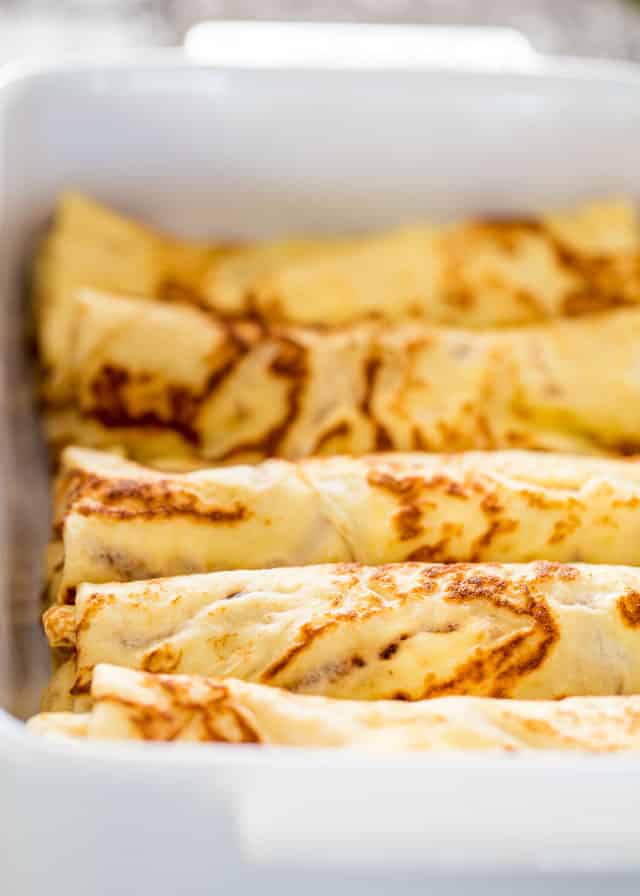 Maple Ricotta Stuffed Crepes lined up in a casserole dish