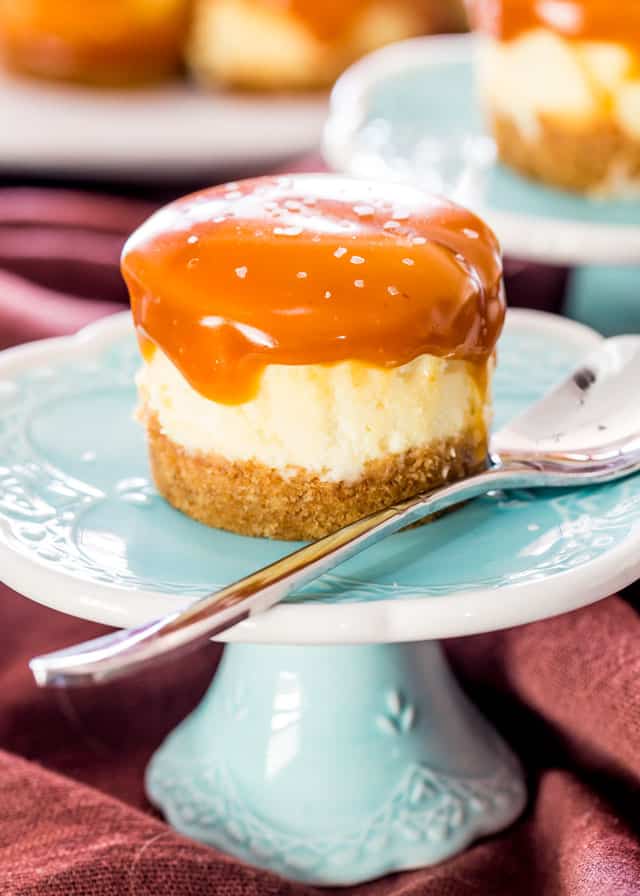a Mini Salted Caramel Cheesecake on a blue dish with a spoon