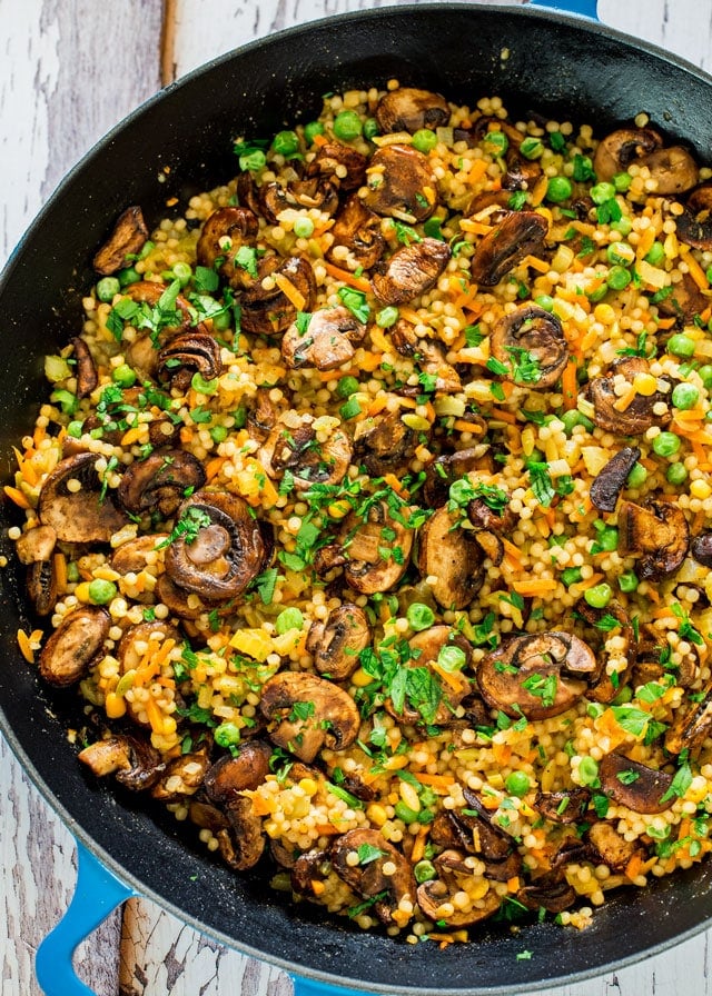 overhead of a paella pan filled with couscous pilaf with sauteed mushrooms