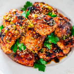 side view shot of grilled harissa chicken thighs in a bowl