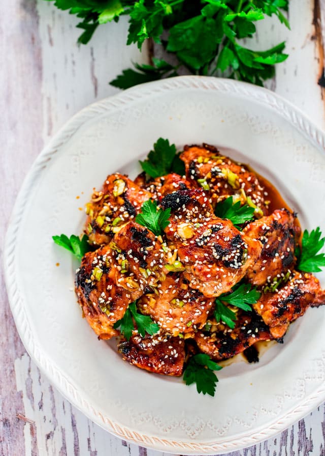 overhead of harissa sesame chicken topped with parsley and sesame seeds