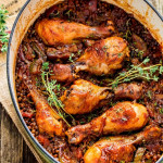 overhead shot of chicken drumsticks and beluga lentils in a pot