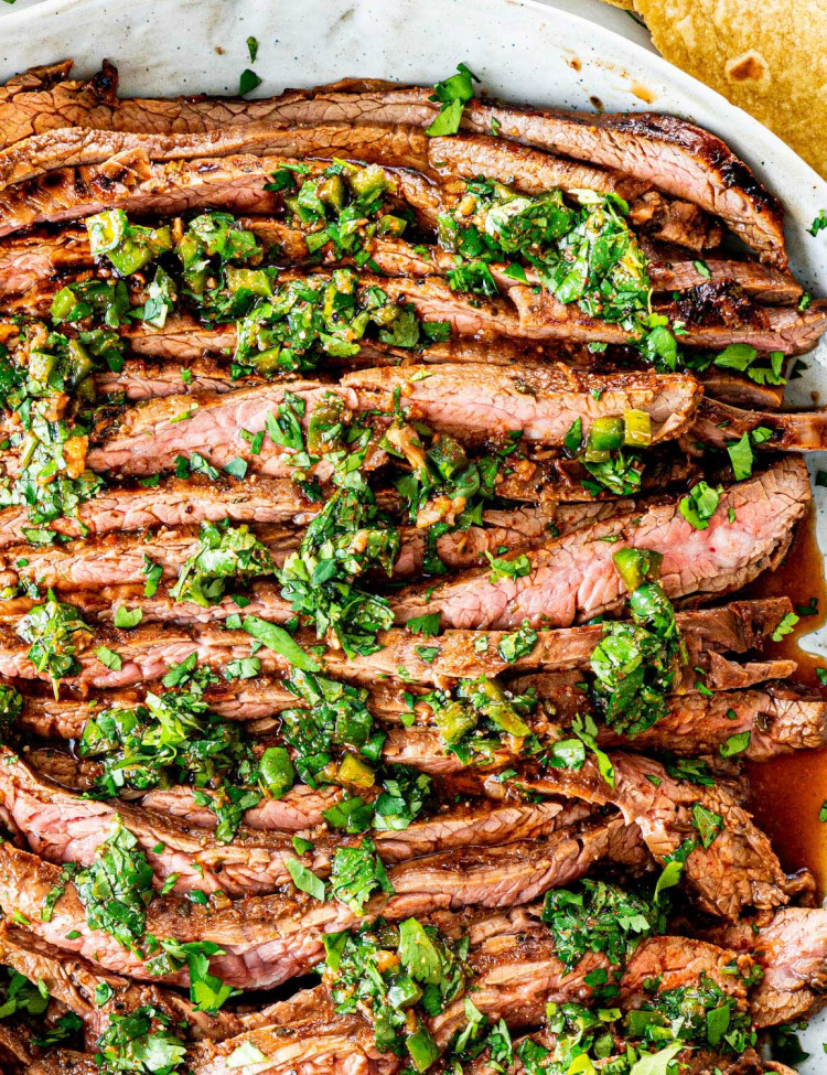 overhead shot of carne asada on a plate topped with chimichurri