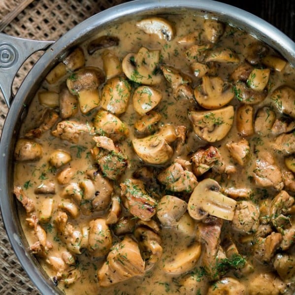 overhead shot of a pot full of chicken and mushrooms in white wine dill sauce