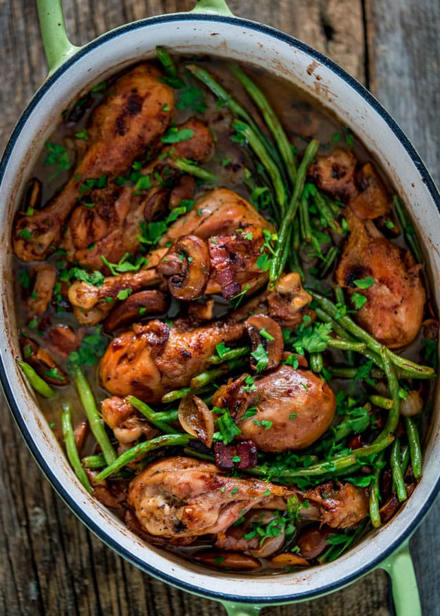 coq au vin with green beans in a large green dutch oven