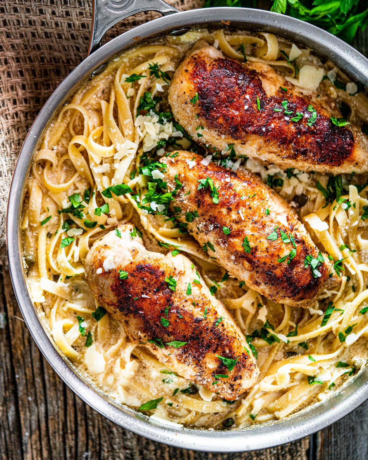 overhead shot of chicken piccata fettuccine in a skillet