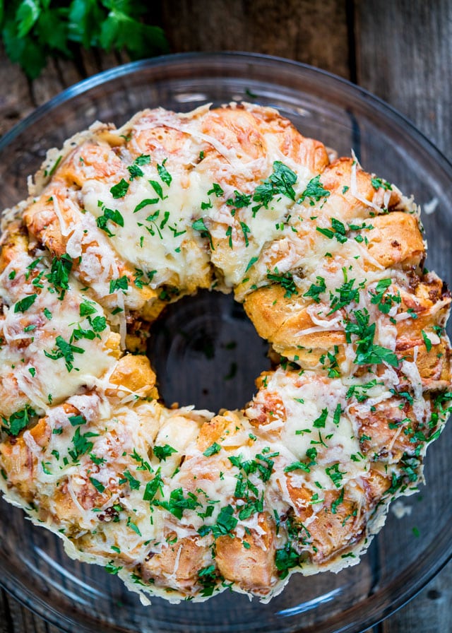 overhead of a sausage ring covered in cheese and parsley