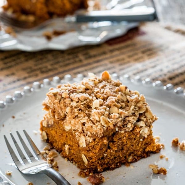 side view shot of a piece of pumpkin crumble cake on a plate with a fork