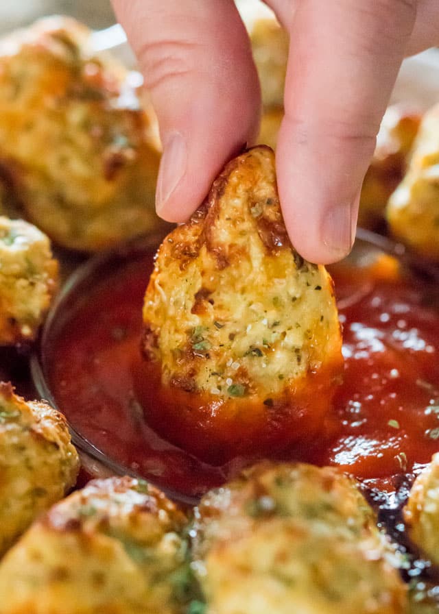 dipping a cauliflower tot into pizza sauce