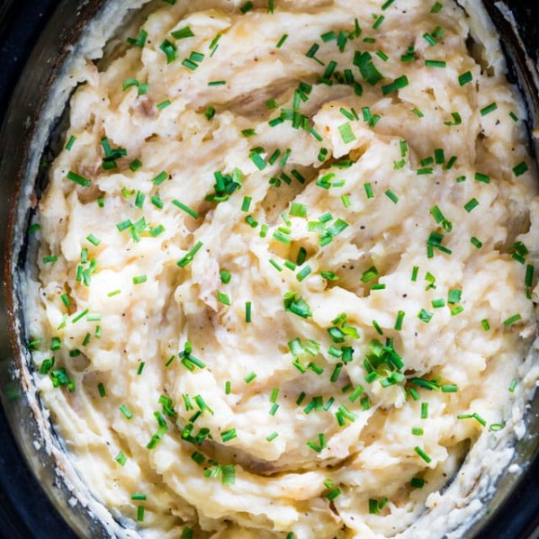 overhead shot of cheesy mashed potatoes in a crock pot