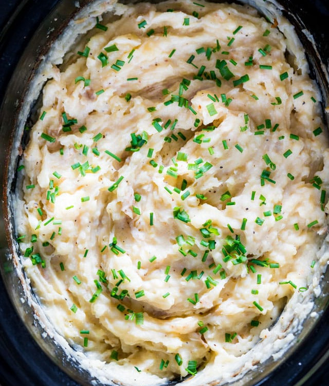 overhead shot of cheesy mashed potatoes in a crock pot