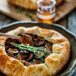 side view shot of honey being drizzled over the fig galette