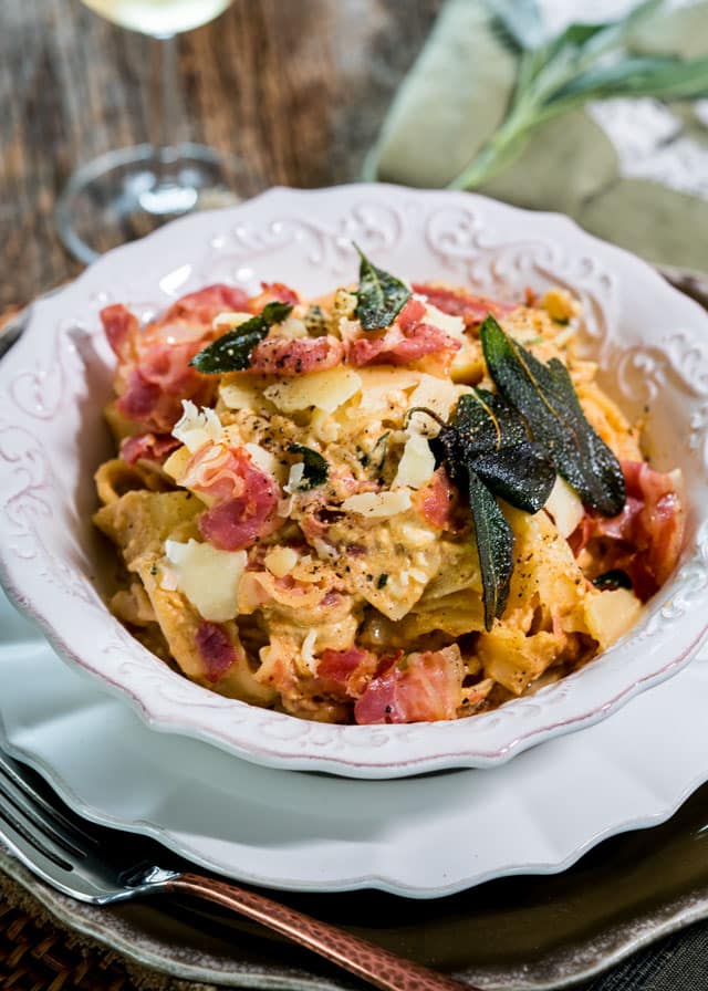 a bowl full of pumpkin goat cheese papardelle, crispy sage, and pancetta