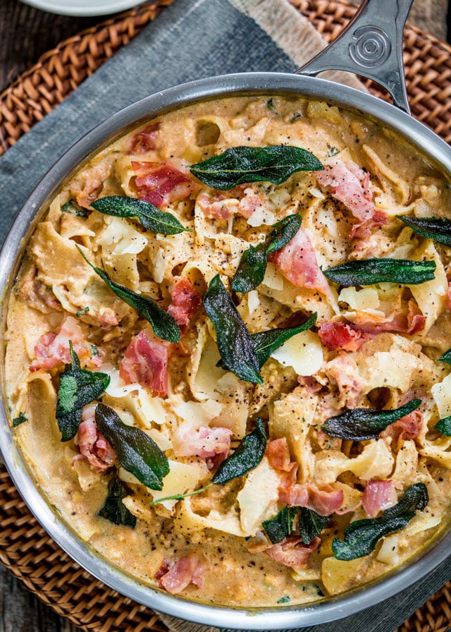 overhead of a skillet filled with pasta, crispy sage, and pancetta