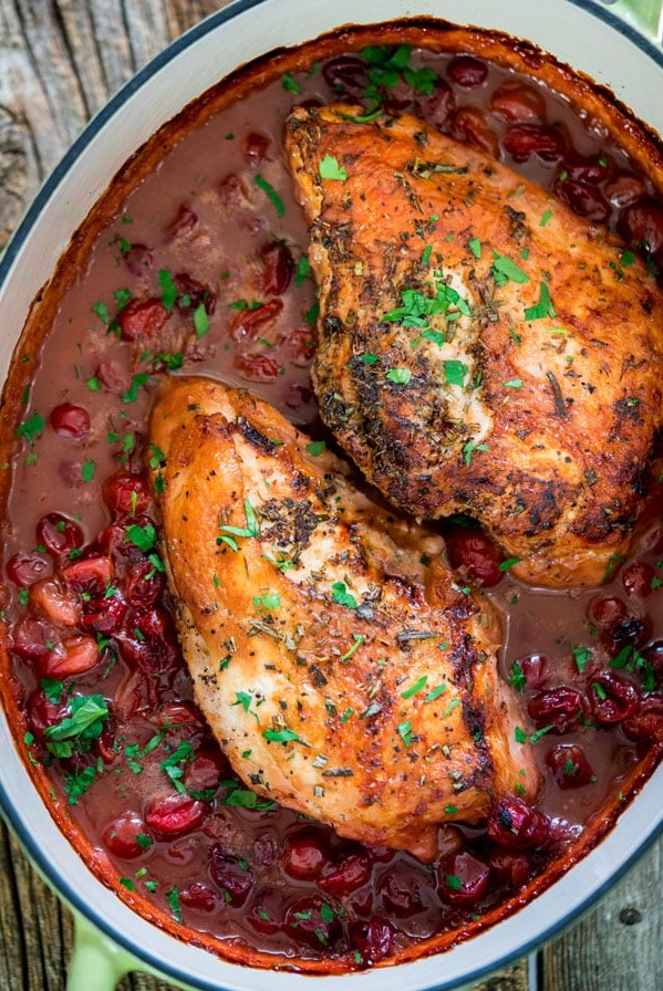 overhead shot of roasted turkey breasts in a pot of cranberries