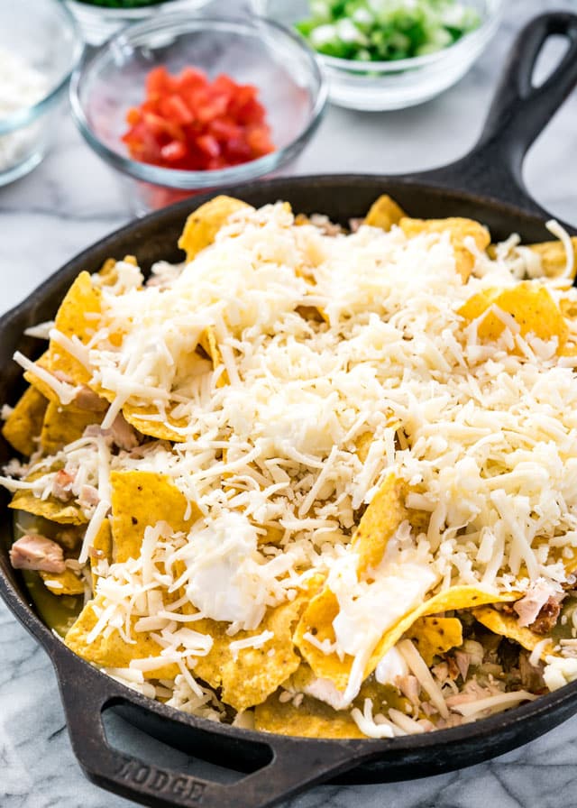 a skillet full of chilaquiles topped with lots of cheese