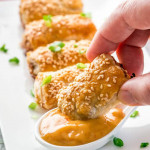 side view shot of a hand dipping an asian pork roll into the sauce