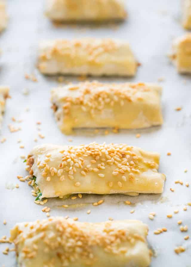 pork rolls sprinkled with sesame seeds ready to be baked in the oven