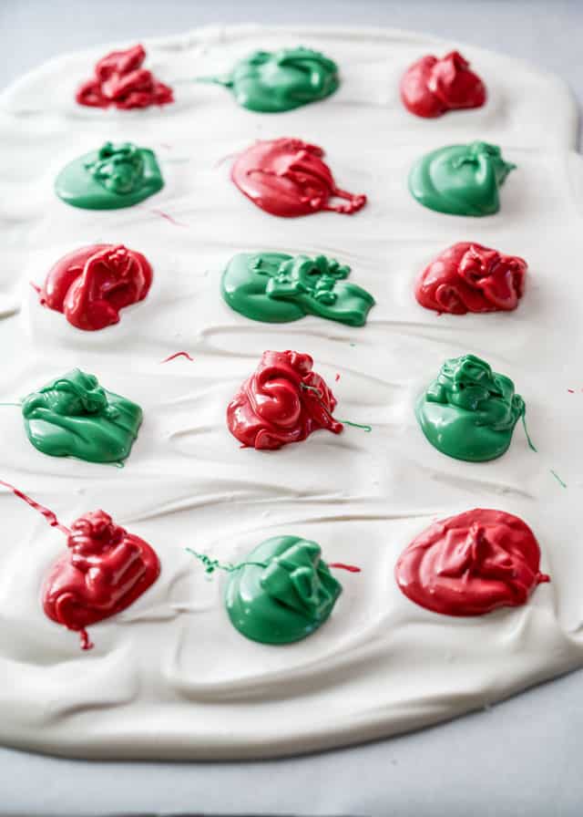 a layer of white chocolate with dollops of alternating red and green dyed chocolate