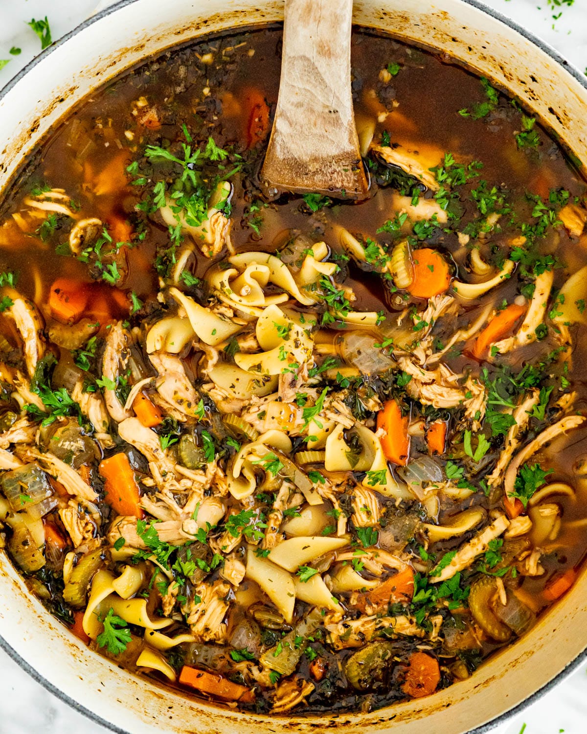 overhead shot of chicken noodle soup in a large dutch oven