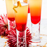 close up shot of 4 grenadine sunrises garnished with orange twists
