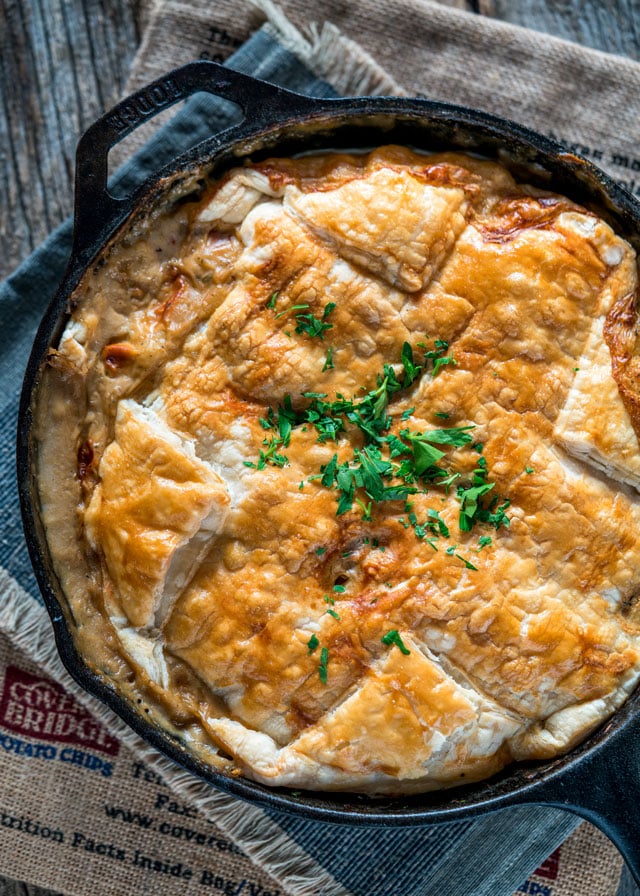 overhead of a skillet with pot pie bubbling around the edges and puff pastry
