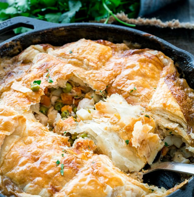 side view shot of a serving spoon taking a scoop of skillet chicken pot pie